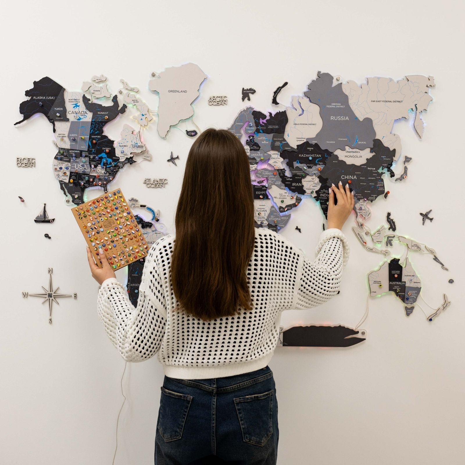 Woman interacting with a world map on a wall