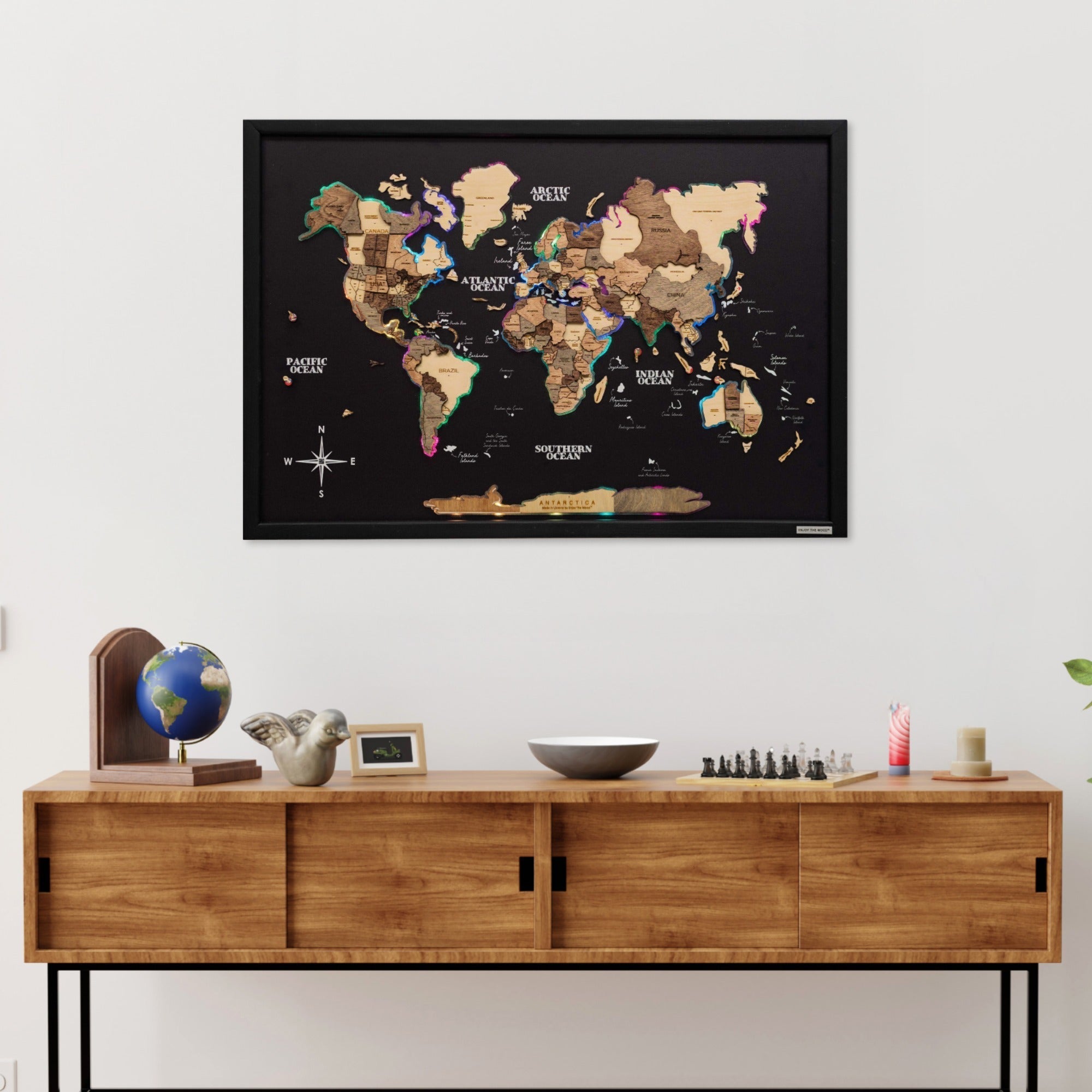 World map poster on a wall above a wooden cabinet with decorative items.