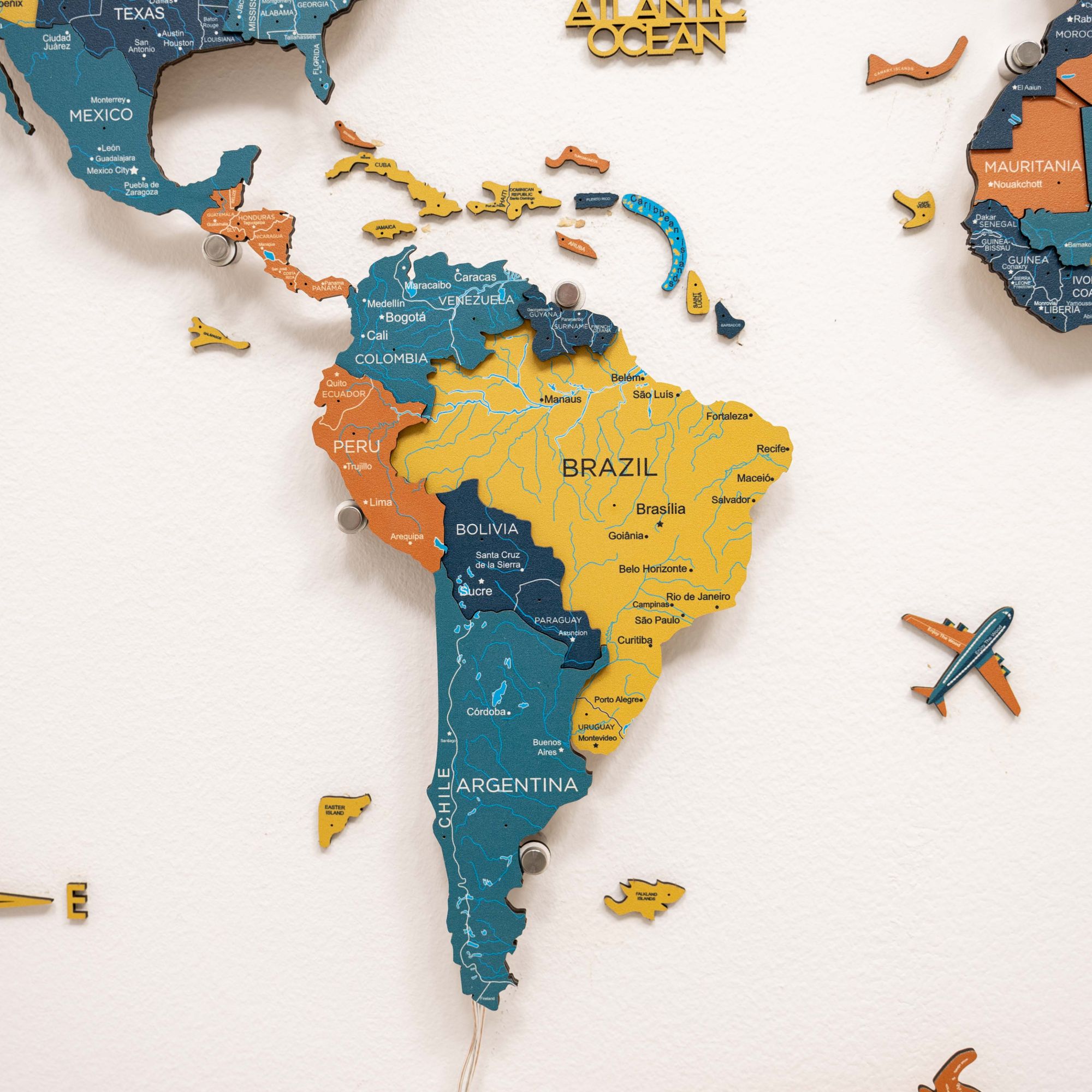 World map with colorful countries and an airplane on a white background