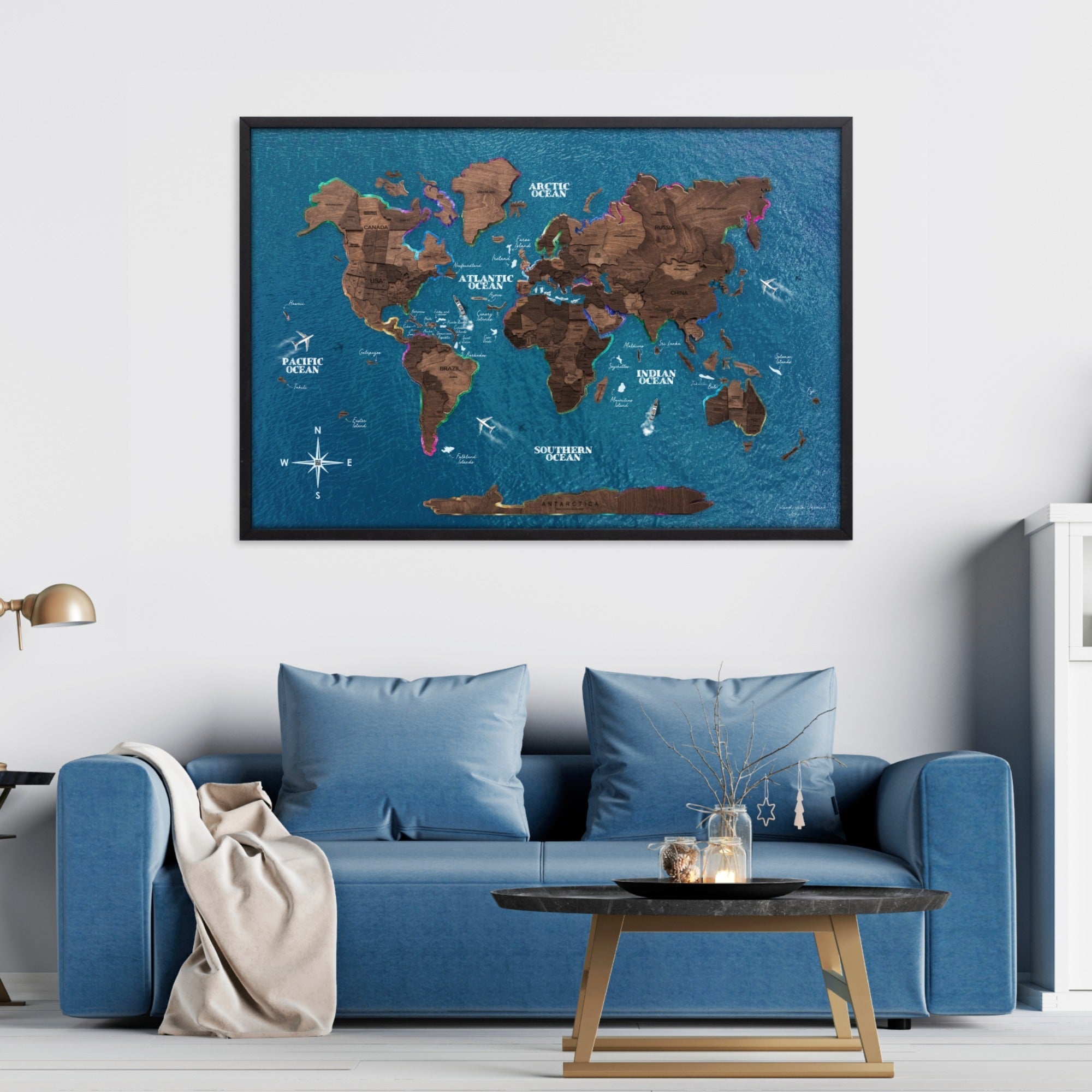 World map poster on a wall above a blue sofa in a living room.