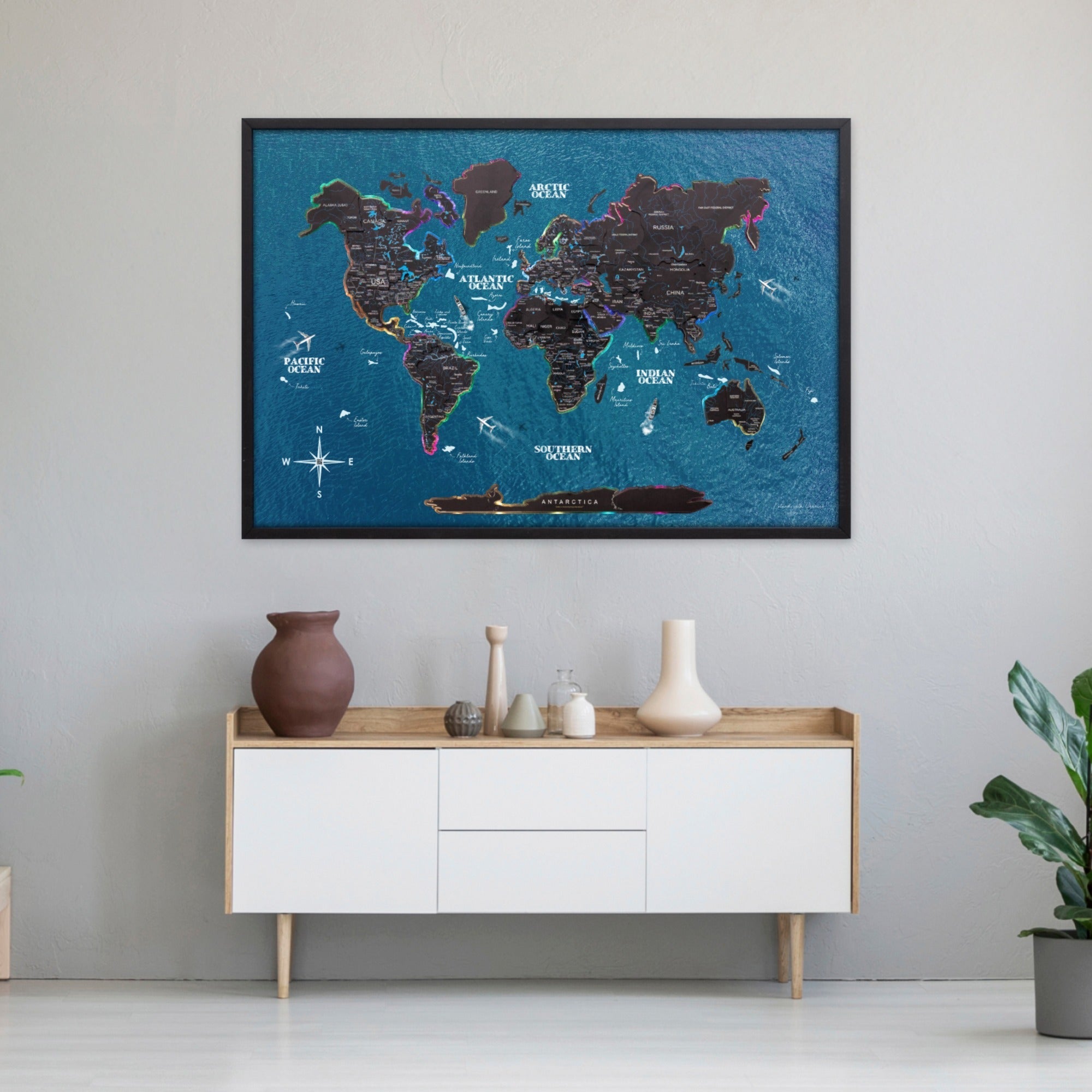 World map poster on a wall above a white cabinet with wooden accents.