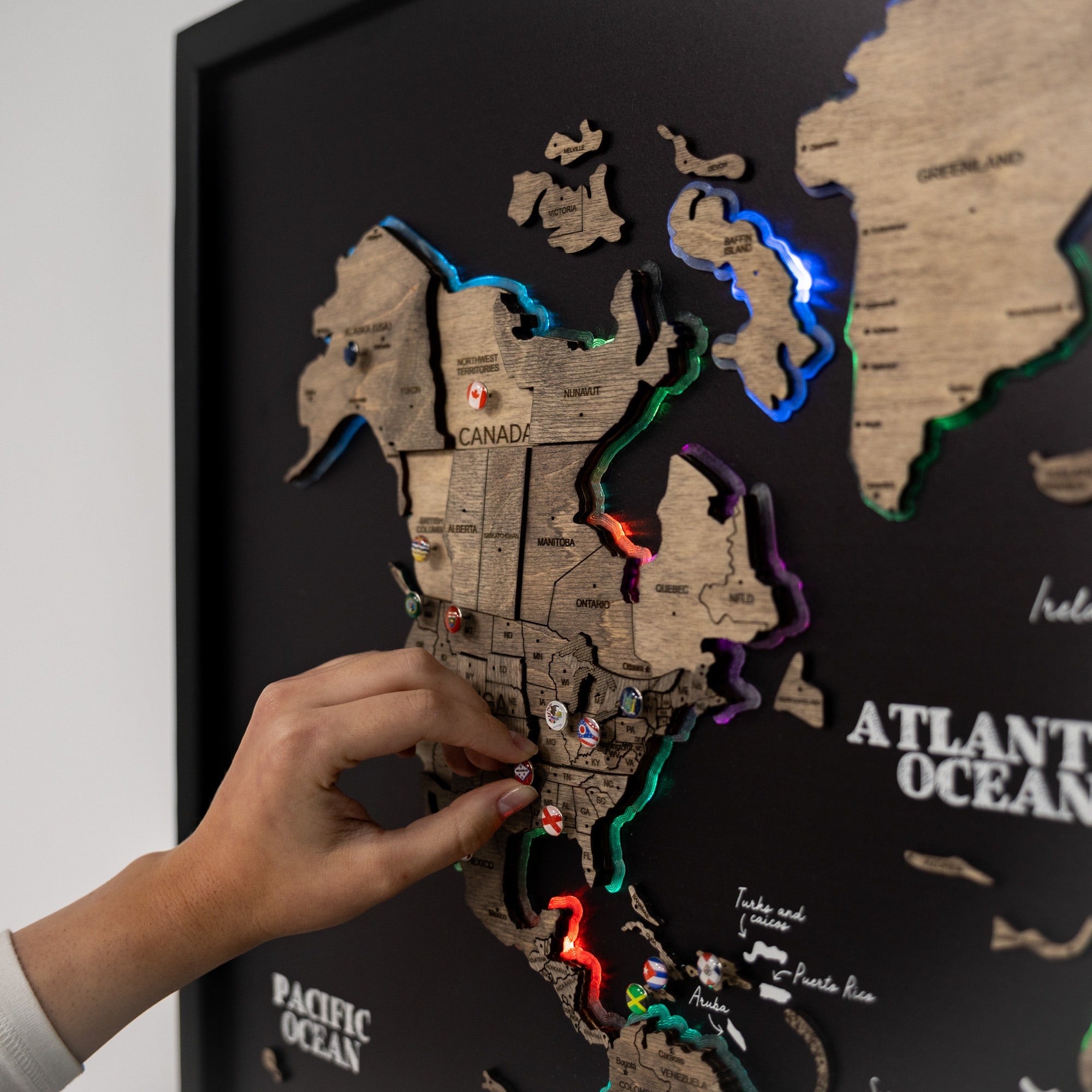 World map with colorful lights and a hand interacting with it, on a black background.