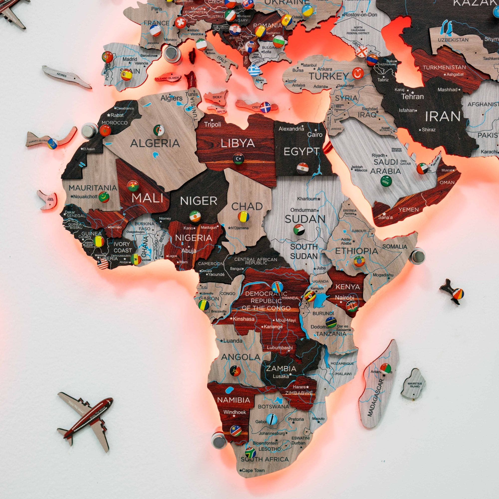 Map of Africa with country names and flags, illuminated by pink light, on a white background.