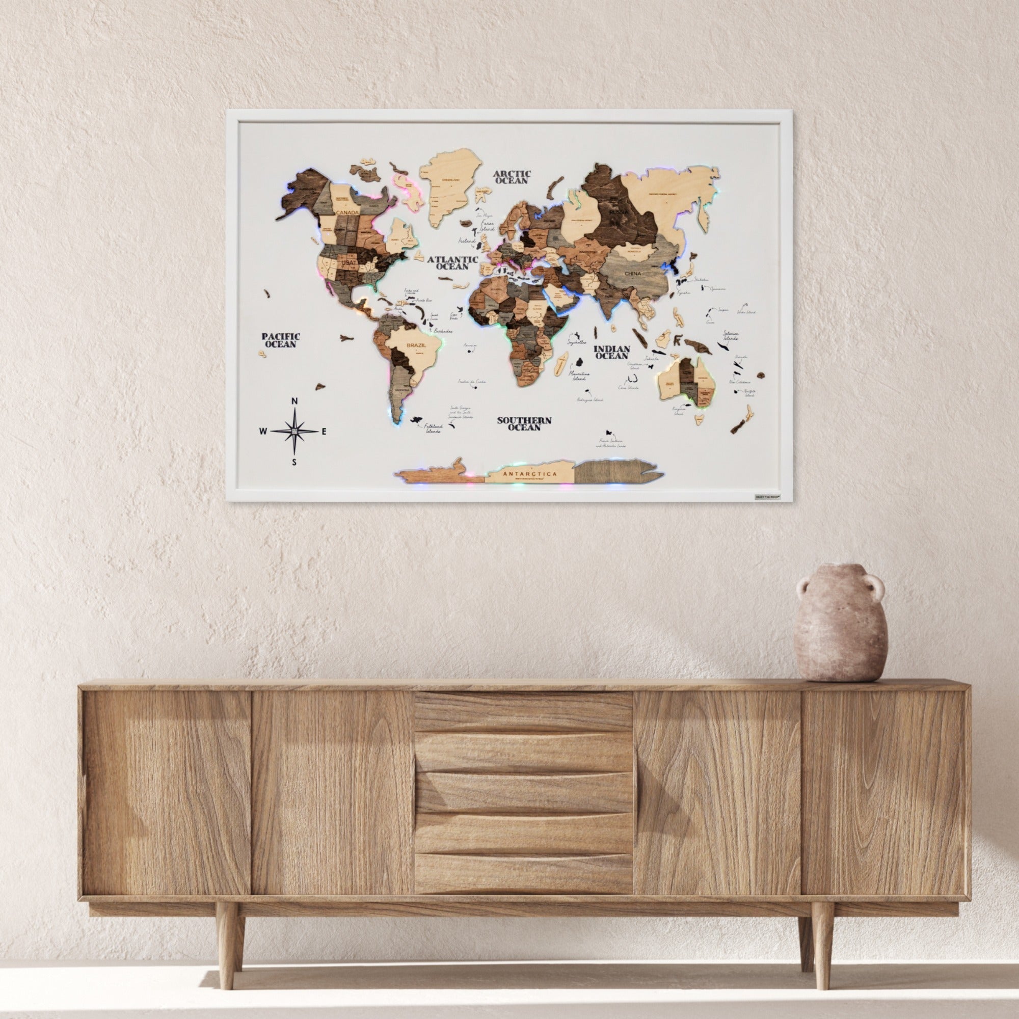 World map poster on a wall above a wooden sideboard