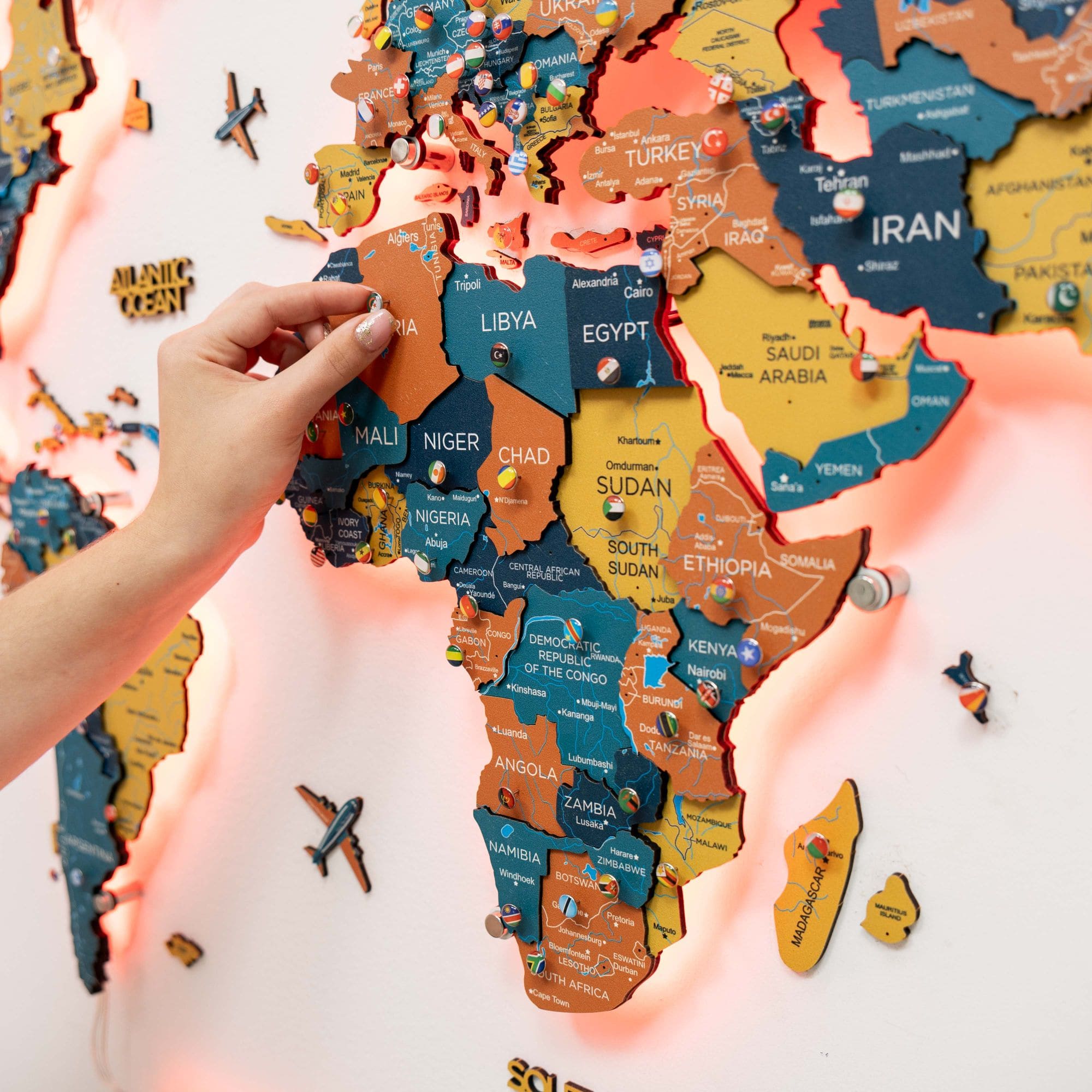 World map puzzle with hands assembling pieces on a light background