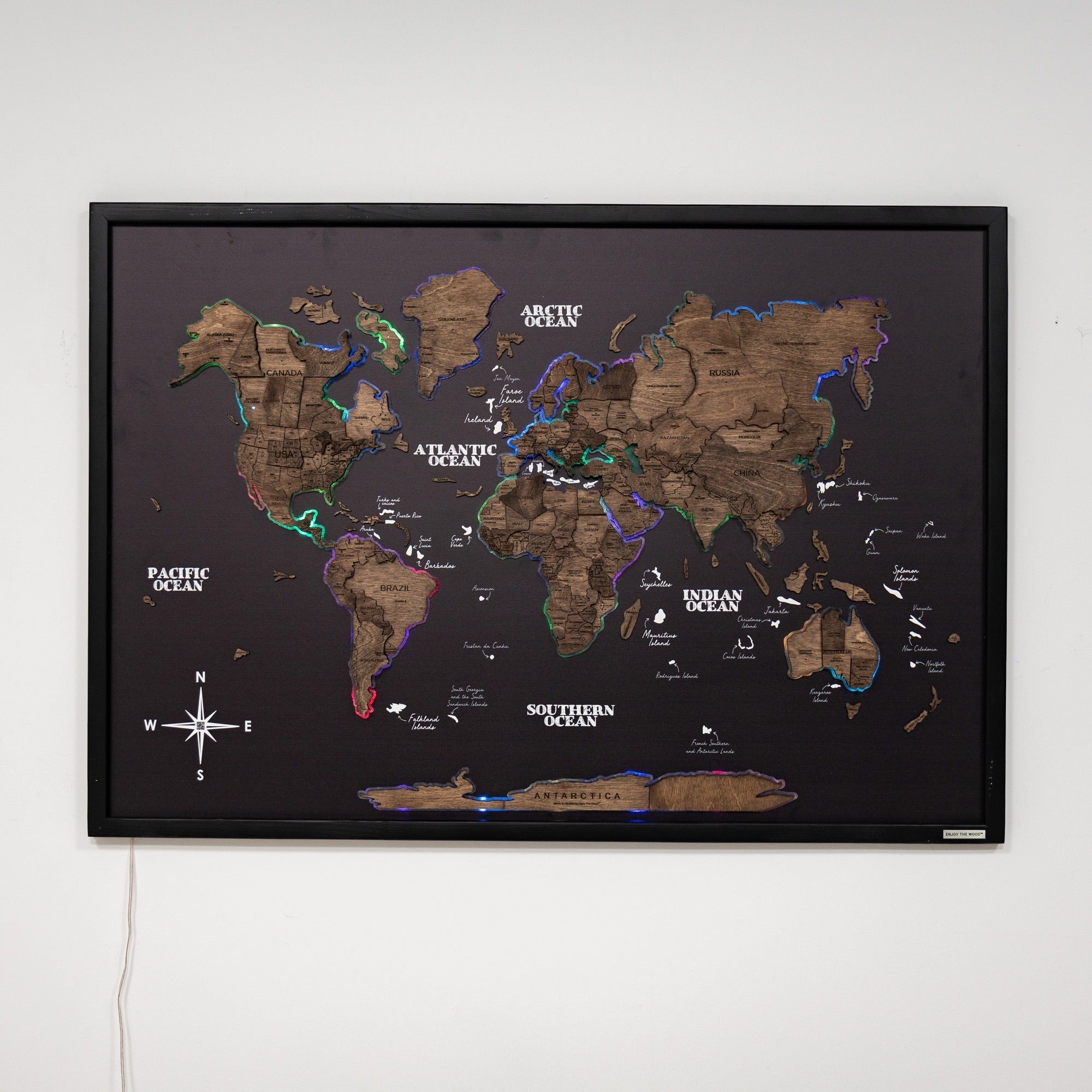 World map poster with a black frame on a white wall