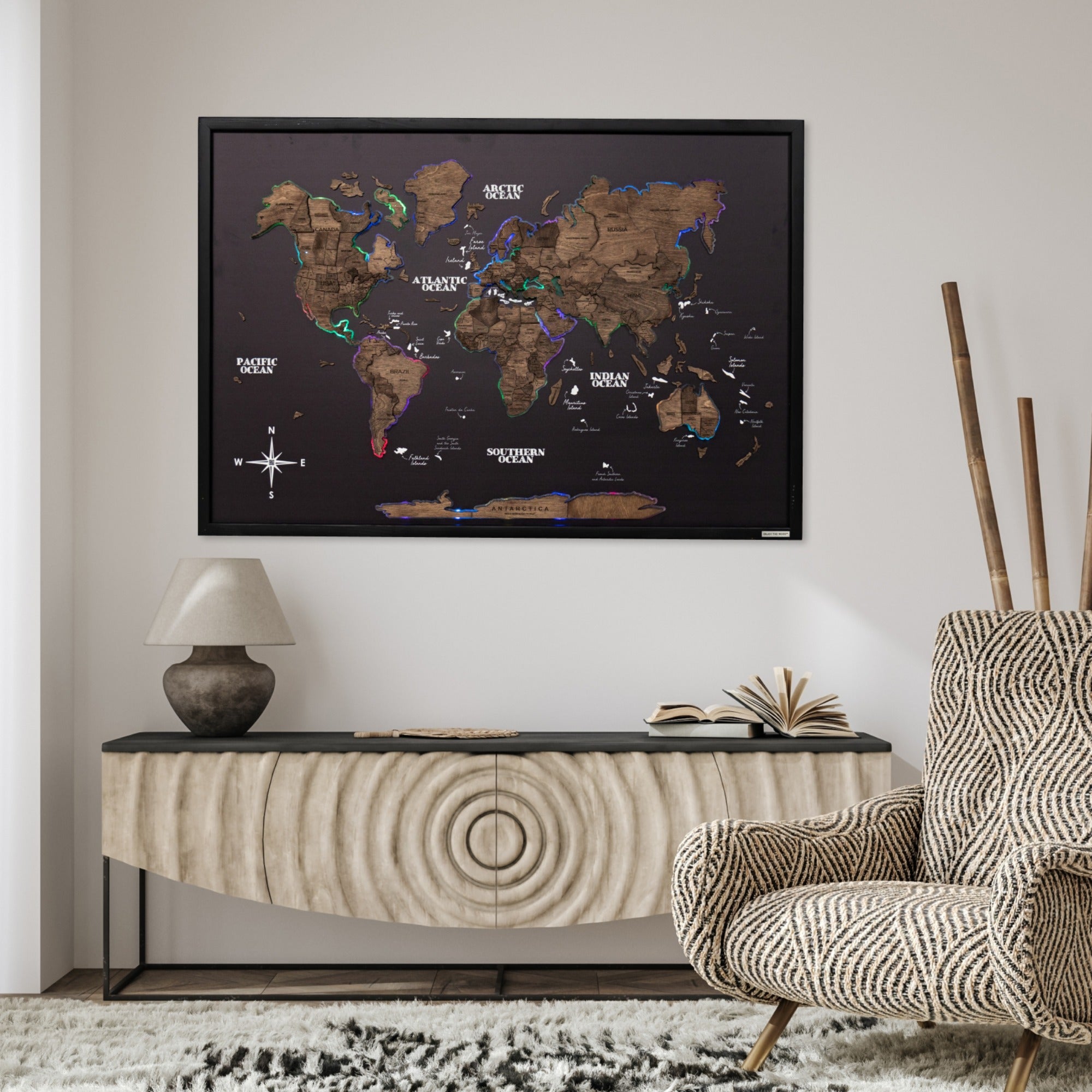 World map poster on a wall above a console table with a chair and lamp in a room.