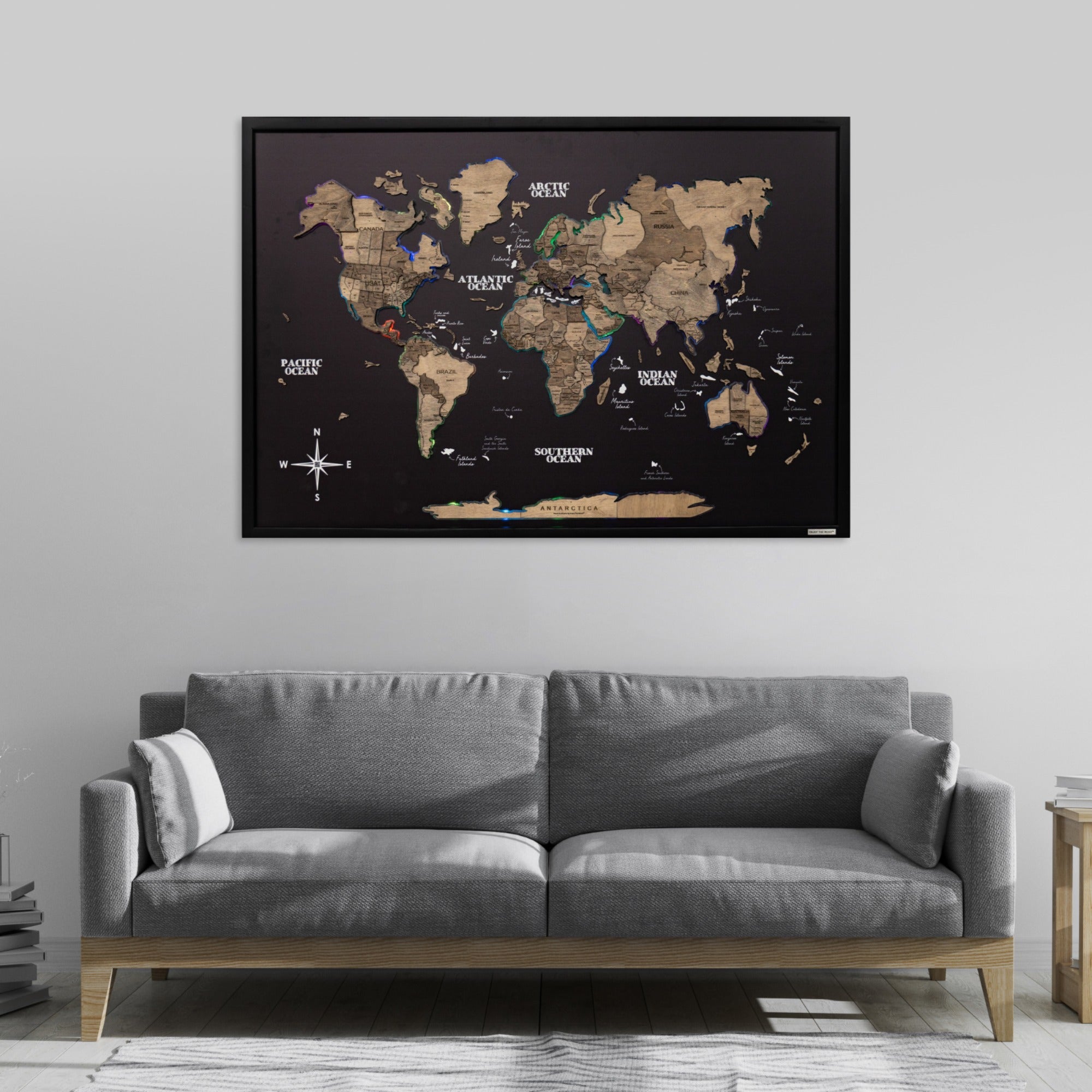 World map poster on a wall above a gray sofa in a living room.