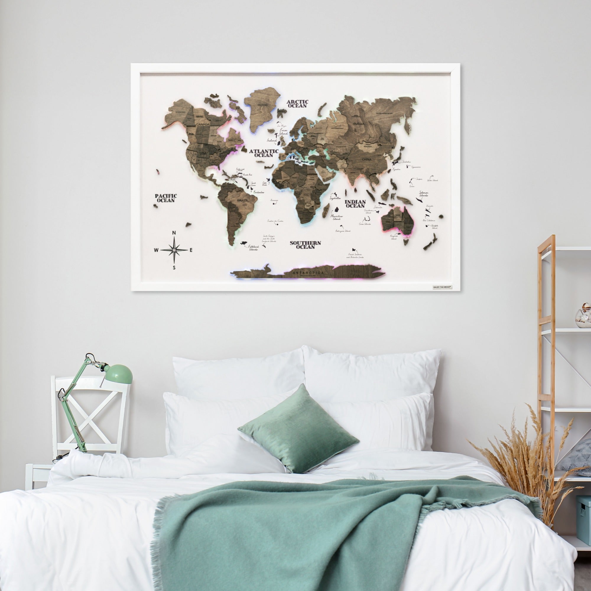 World map poster on a wall above a bed in a bedroom