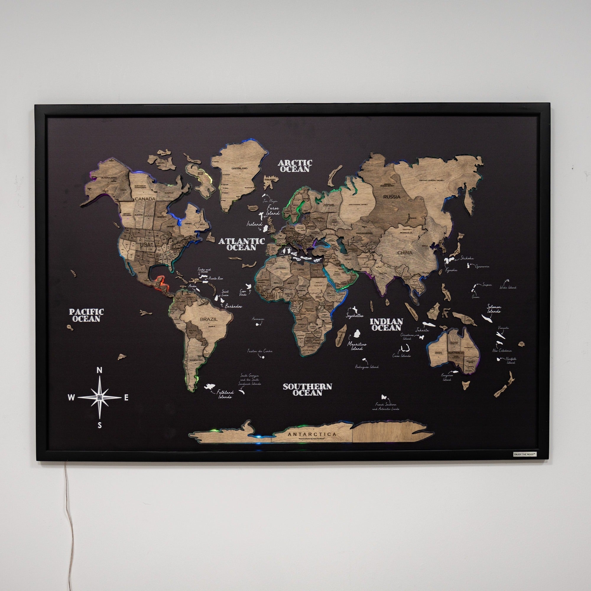 World map poster with black frame on a white wall