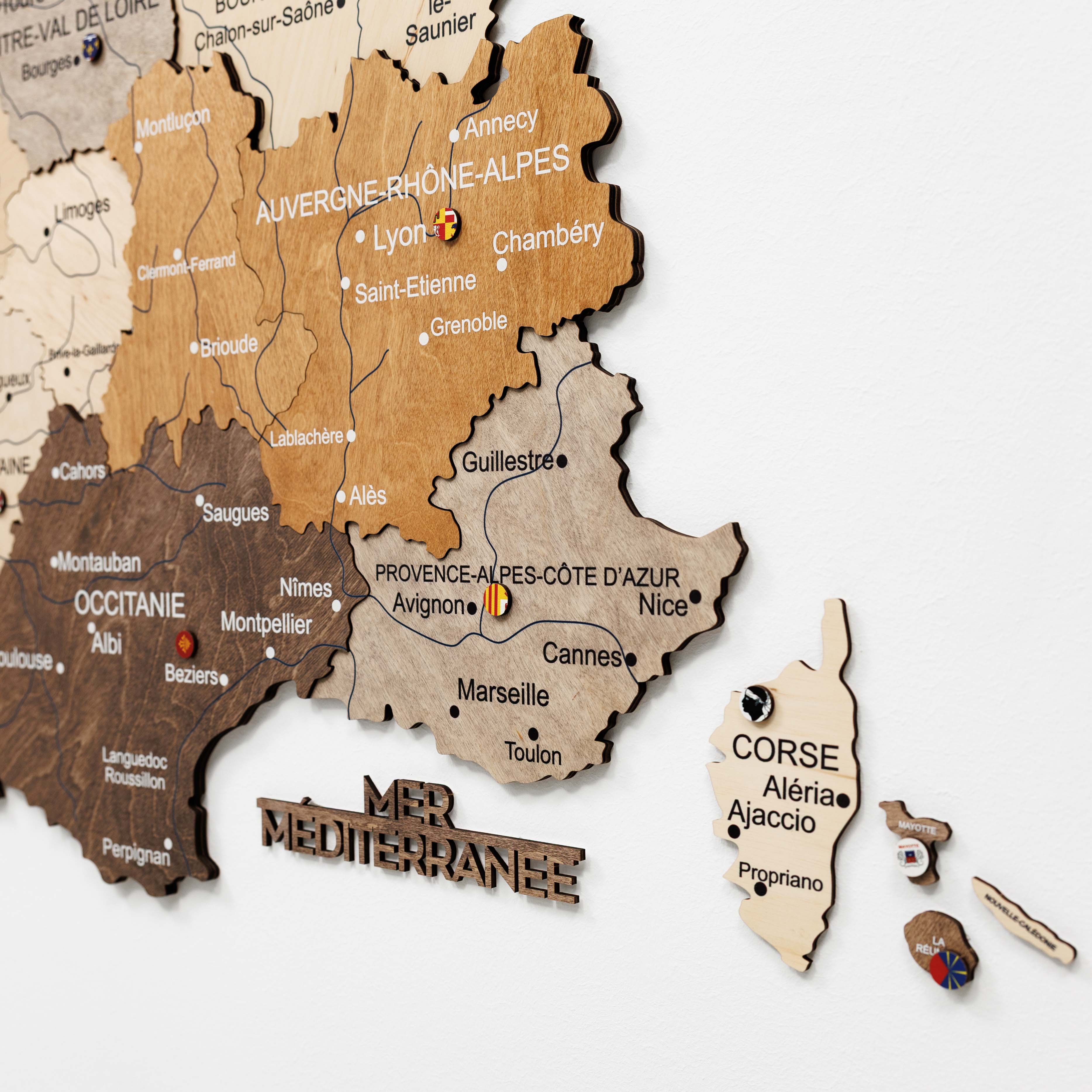Wooden map of France with different regions highlighted on a white background