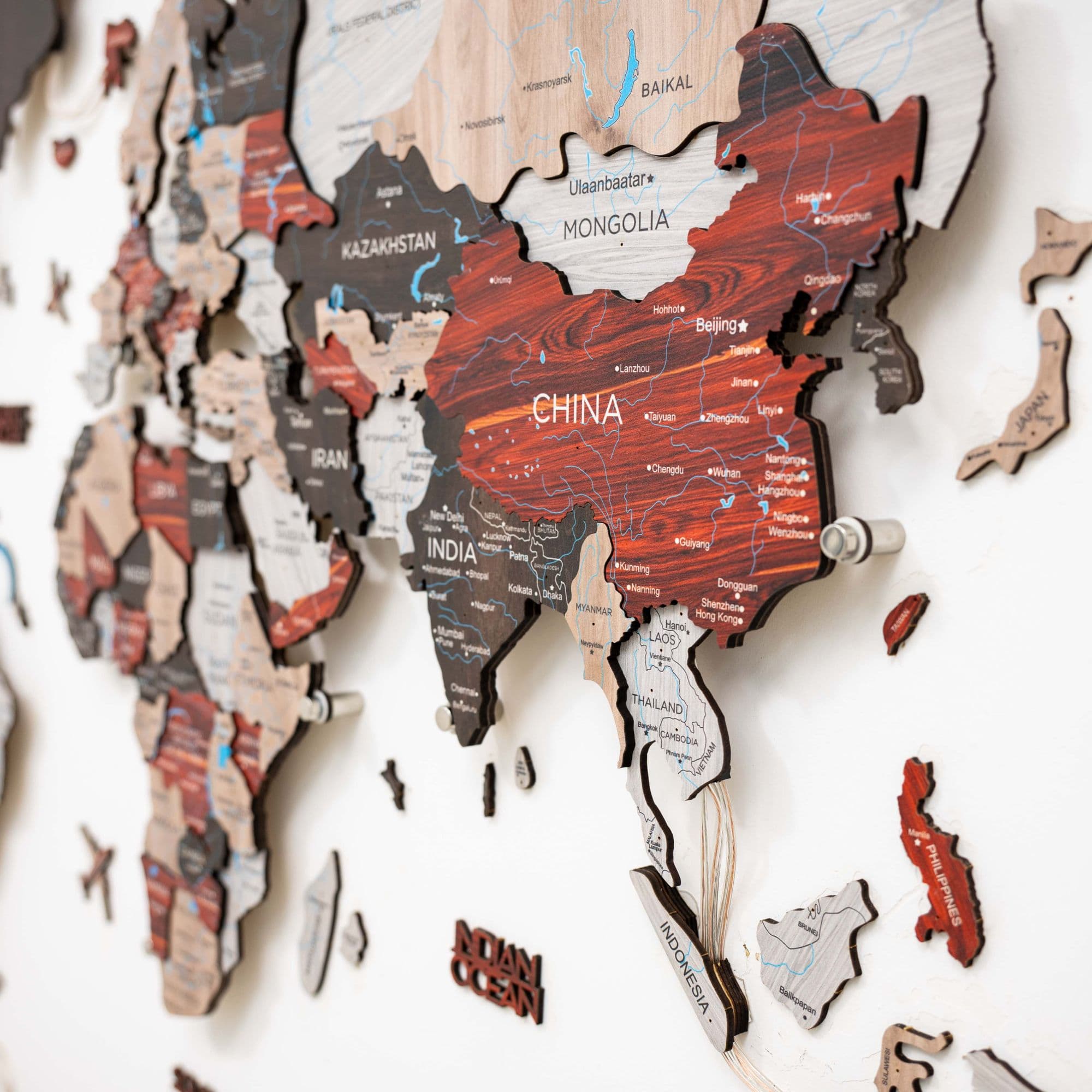 Wooden map of Asia with various countries labeled on a white background